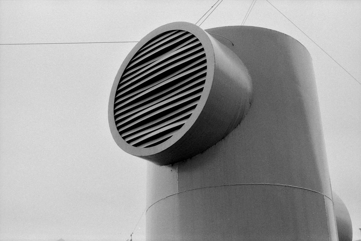 Detalhe ilustrativo de uma saída de ventilação metálica com grelha circular.